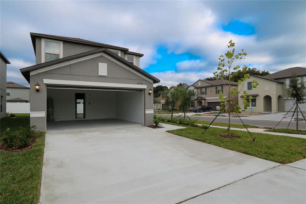 4714 Norman Oak Place Tampa, FL 33619 - Photo 21 of 32 a front view of a house with a yard and garage