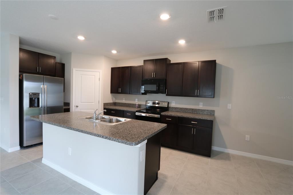 4714 Norman Oak Place Tampa, FL 33619 - Photo 3 of 32 a kitchen with stainless steel appliances granite countertop a sink a stove and a refrigerator