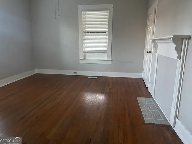 an empty room with wooden floor and window