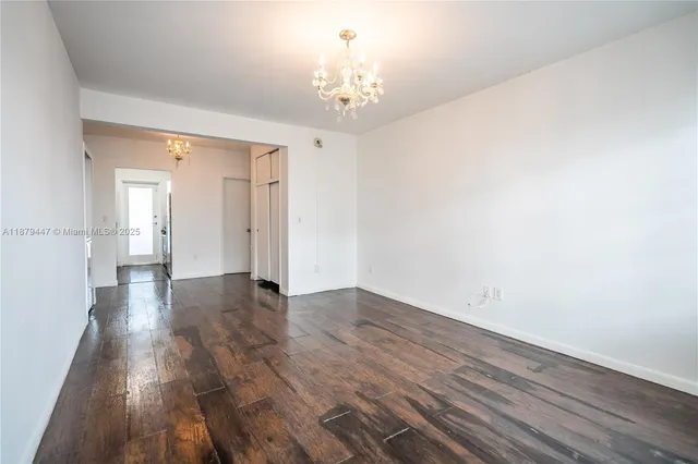 a view of a hallway with wooden floor and a chandelier