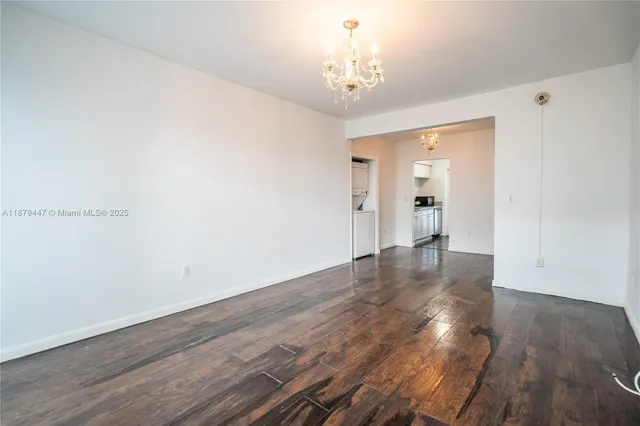 a view of a room with wooden floor and chandelier