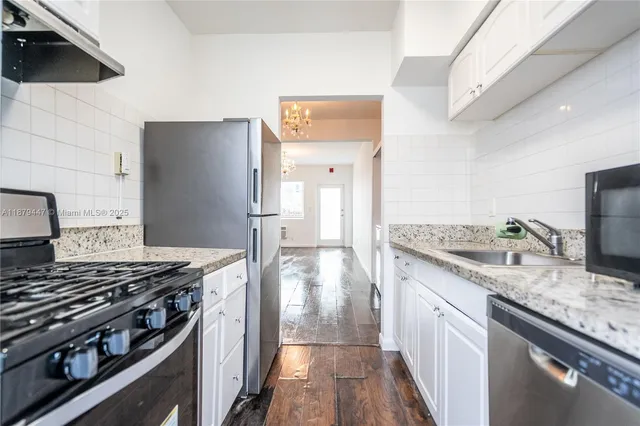 a kitchen with granite countertop a sink stove and refrigerator
