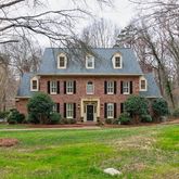 a front view of a house with a yard and trees