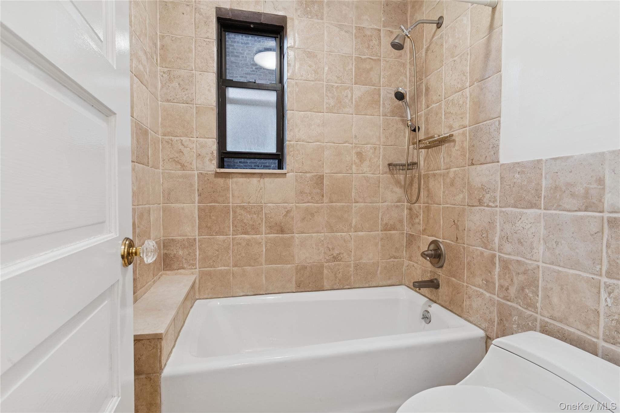 73-20 Austin Street, Unit 2E Queens, NY 11375 - Photo 11 of 13 a bathroom with a bathtub and window