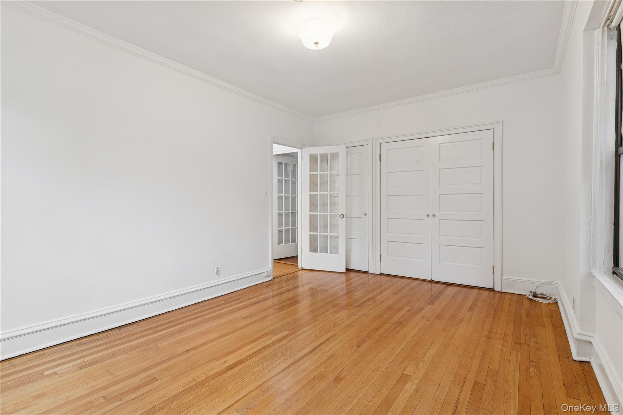 73-20 Austin Street, Unit 2E Queens, NY 11375 - Photo 7 of 13 a view of an empty room with wooden floor