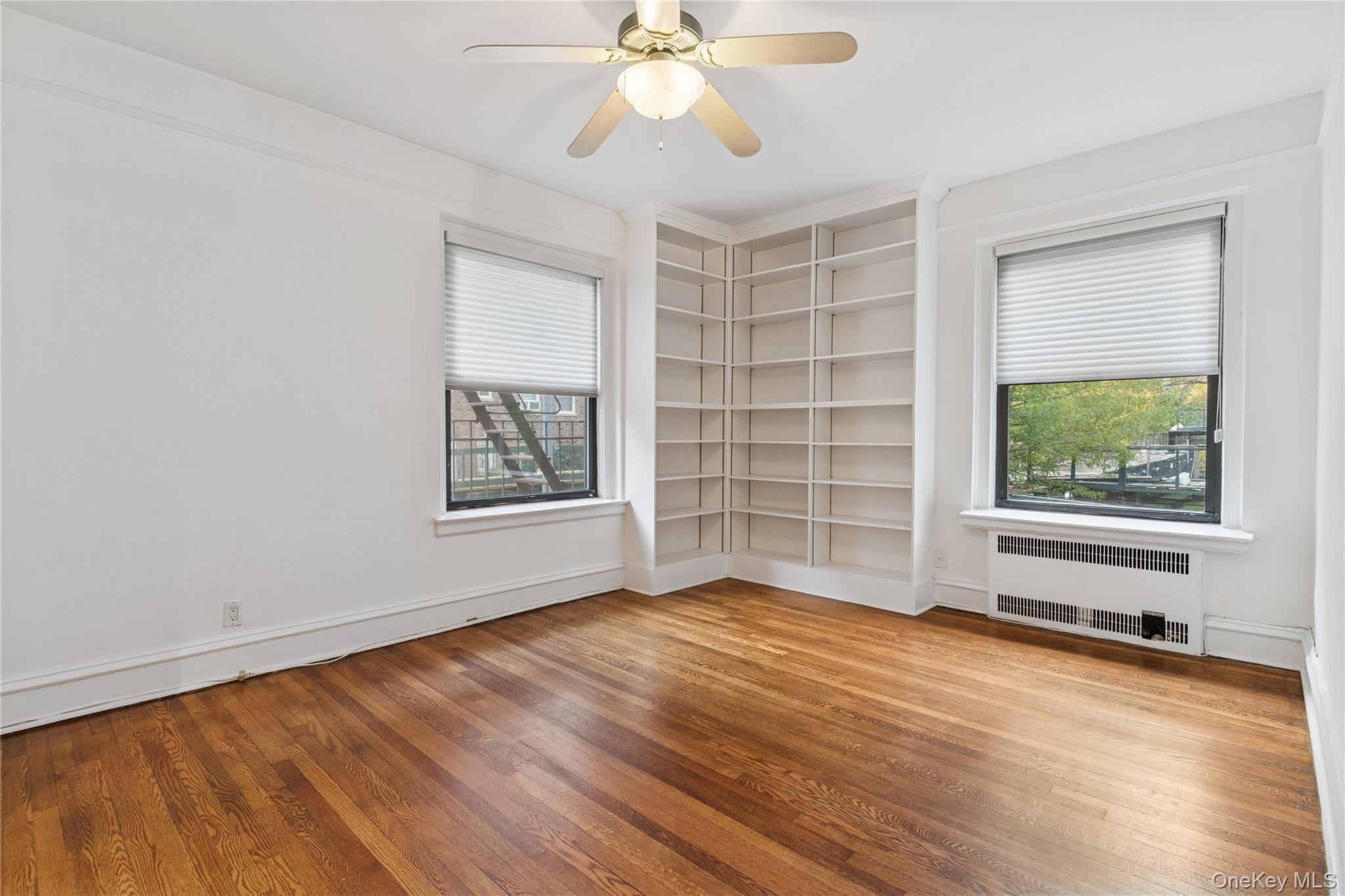 73-20 Austin Street, Unit 2E Queens, NY 11375 - Photo 8 of 13 wooden floor in an empty room with a window