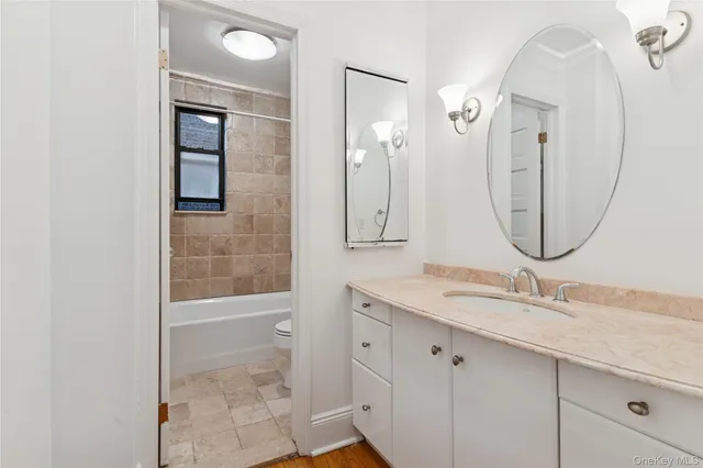 a bathroom with a granite countertop sink a mirror and a shower