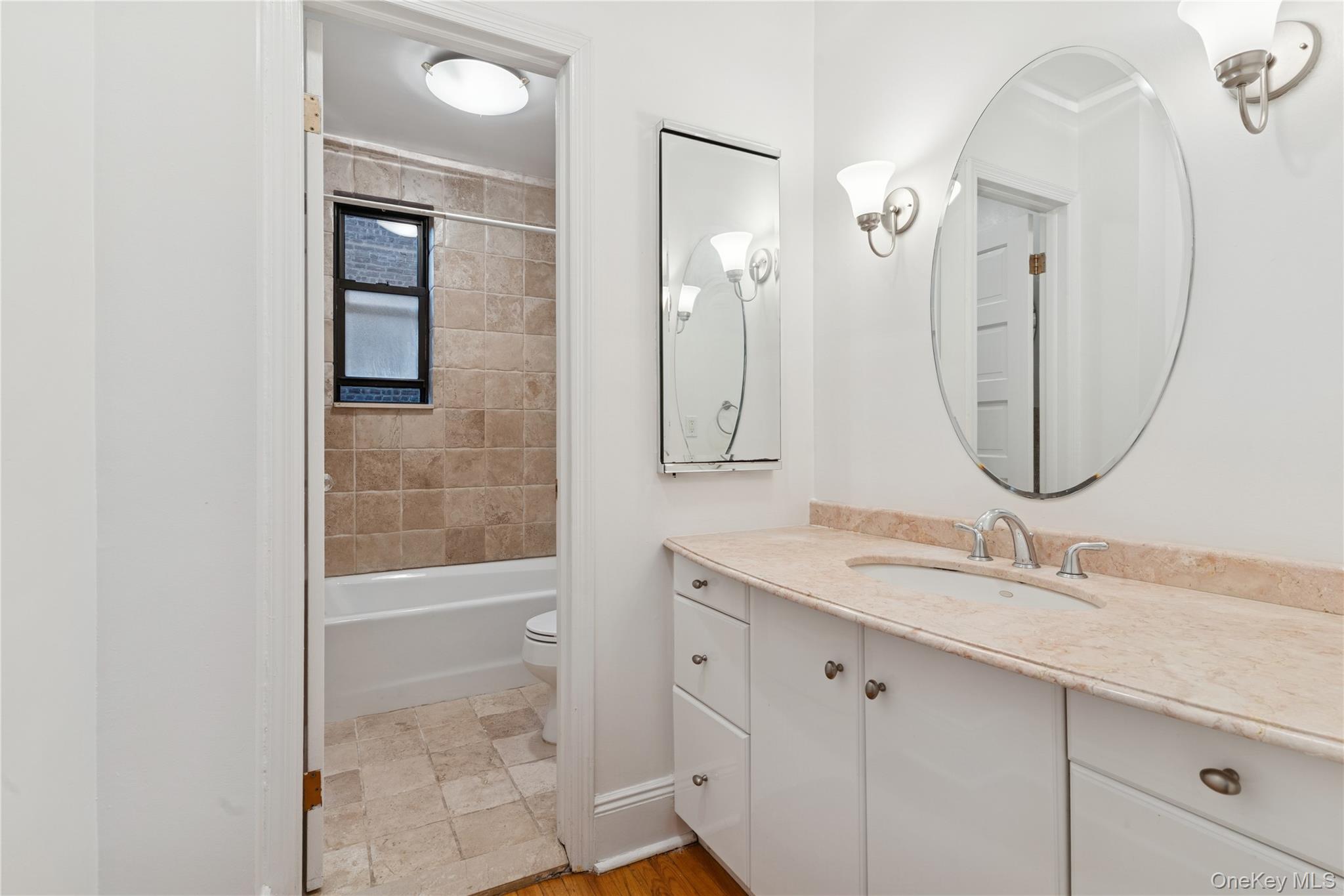 73-20 Austin Street, Unit 2E Queens, NY 11375 - Photo 10 of 13 a bathroom with a granite countertop sink a mirror and a shower