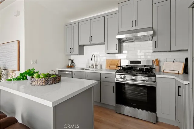 a kitchen with granite countertop white cabinets and stainless steel appliances