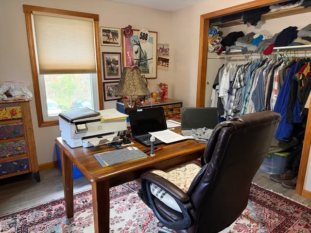 a view of a workspace with furniture and a window