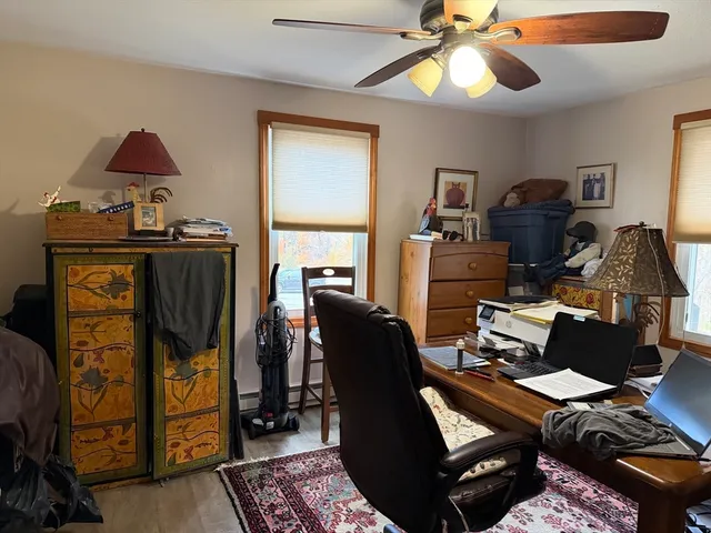 a view of a workspace with furniture and a window