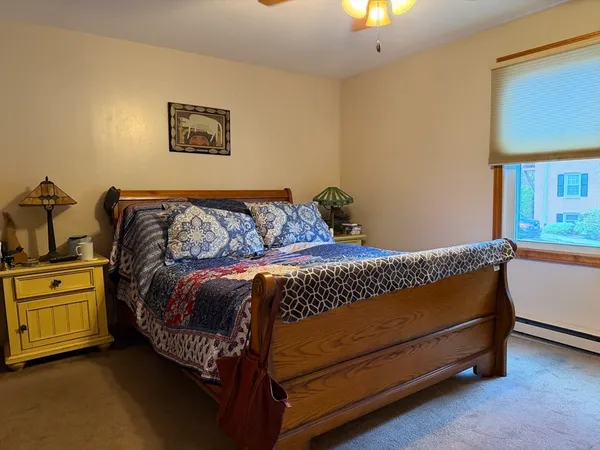 a bed sitting in a bedroom next to a lamp