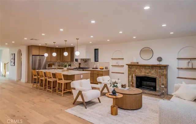 a living room with furniture a fireplace and kitchen view