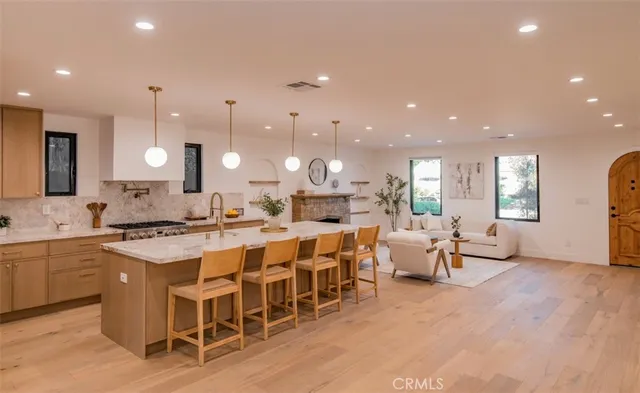 a large kitchen with a large counter top furniture appliances and a view of living room