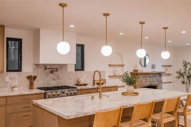 a kitchen with stainless steel appliances granite countertop a stove a sink and a wooden floor