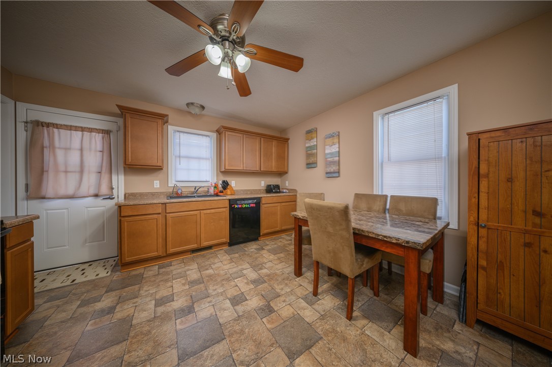 4431 7th Street Northwest Canton, OH 44708 - Photo 4 of 23 Kitchen with stone finish flooring, wood finish cabinetry, a ceiling fan, and black dishwasher