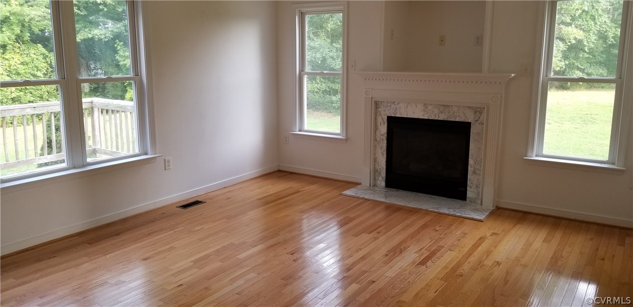 17175 Coatesville Road Beaverdam, VA 23015 - Photo 5 of 16 an empty room with wooden floor fireplace and windows