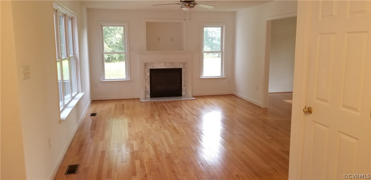 17175 Coatesville Road Beaverdam, VA 23015 - Photo 6 of 16 an empty room with wooden floor fireplace and windows