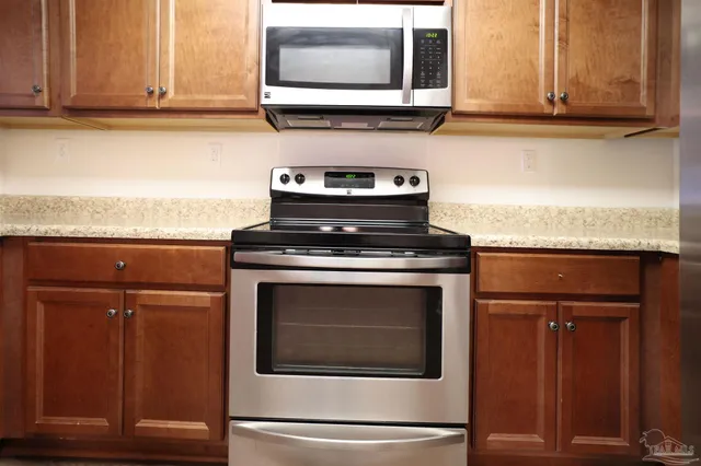 a stove top oven sitting inside of a kitchen and granite counter tops