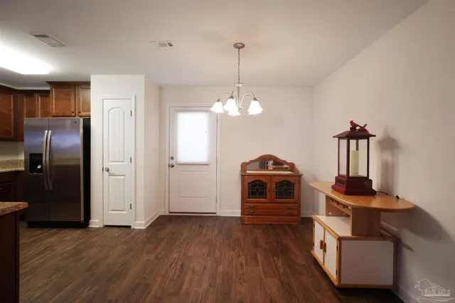 a view of a room with wooden floor electronic appliances and kitchen view