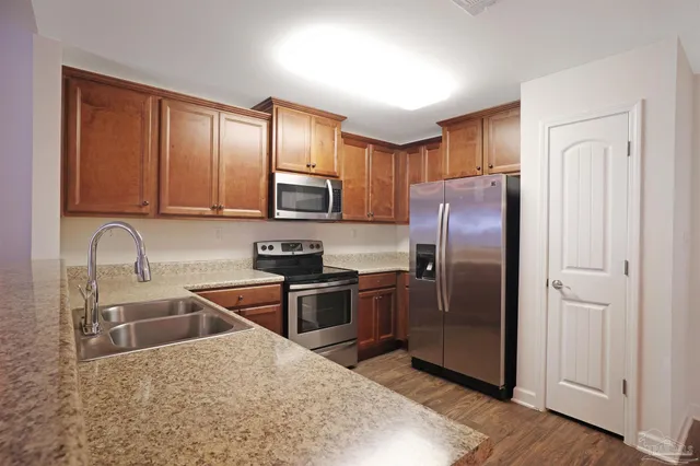 a kitchen with stainless steel appliances granite countertop a refrigerator sink and stove