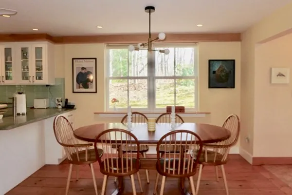 a view of a a dining room with furniture window and wooden floor