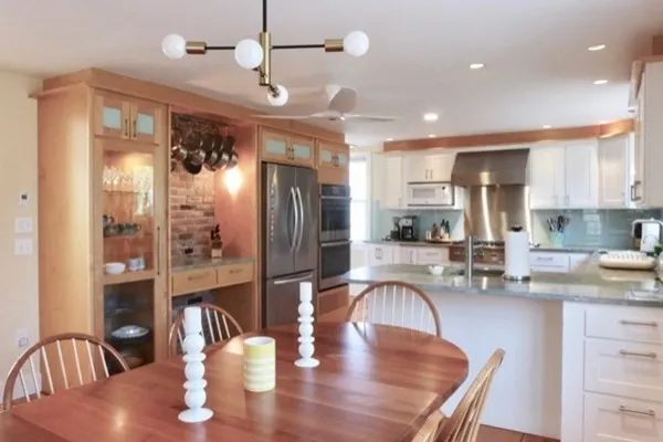 a kitchen with granite countertop stainless steel appliances a dining table and chairs