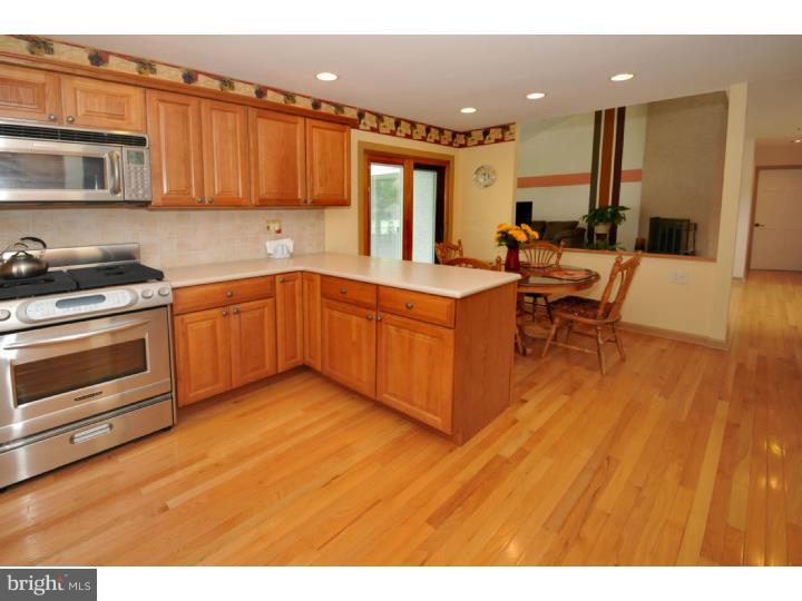 85 Kent Road Huntingdon Valley, PA 19006 - Photo 15 of 25 a kitchen with stainless steel appliances granite countertop a stove a sink dishwasher and a microwave oven with wooden floor