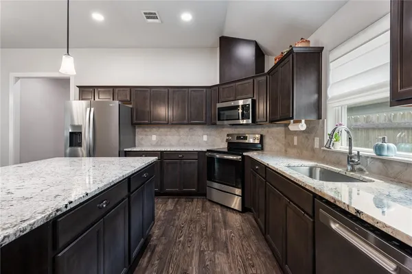 a kitchen with stainless steel appliances granite countertop counter space a sink and cabinets