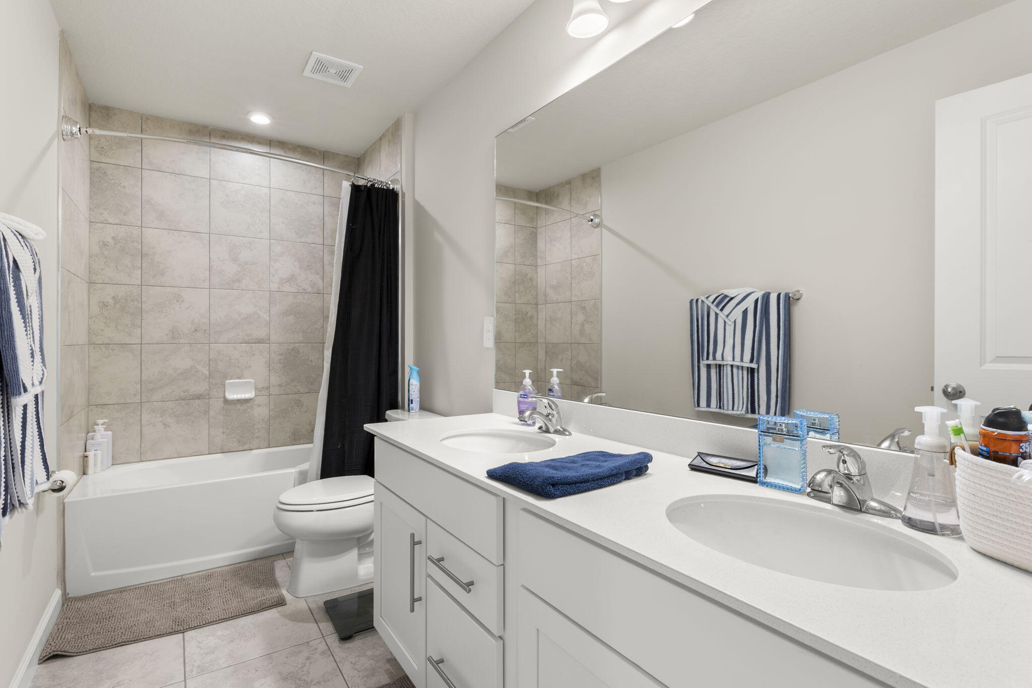 12291 Southwest Forli Way Port St. Lucie, FL 34987 - Photo 29 of 47 a bathroom with a double vanity sink toilet mirror and bathtub