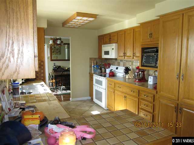 14595 Geronimo Trail Reno, NV 89521 - Photo 6 of 13 a kitchen with sink refrigerator and cabinets