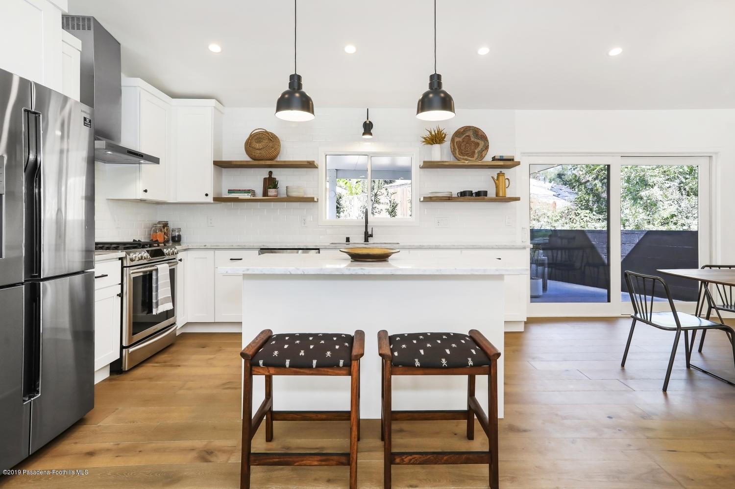 4817 Lockhaven Avenue Los Angeles, CA 90041 - Photo 12 of 34 a kitchen with stainless steel appliances granite countertop a stove a refrigerator a oven a sink with a dining table and chairs