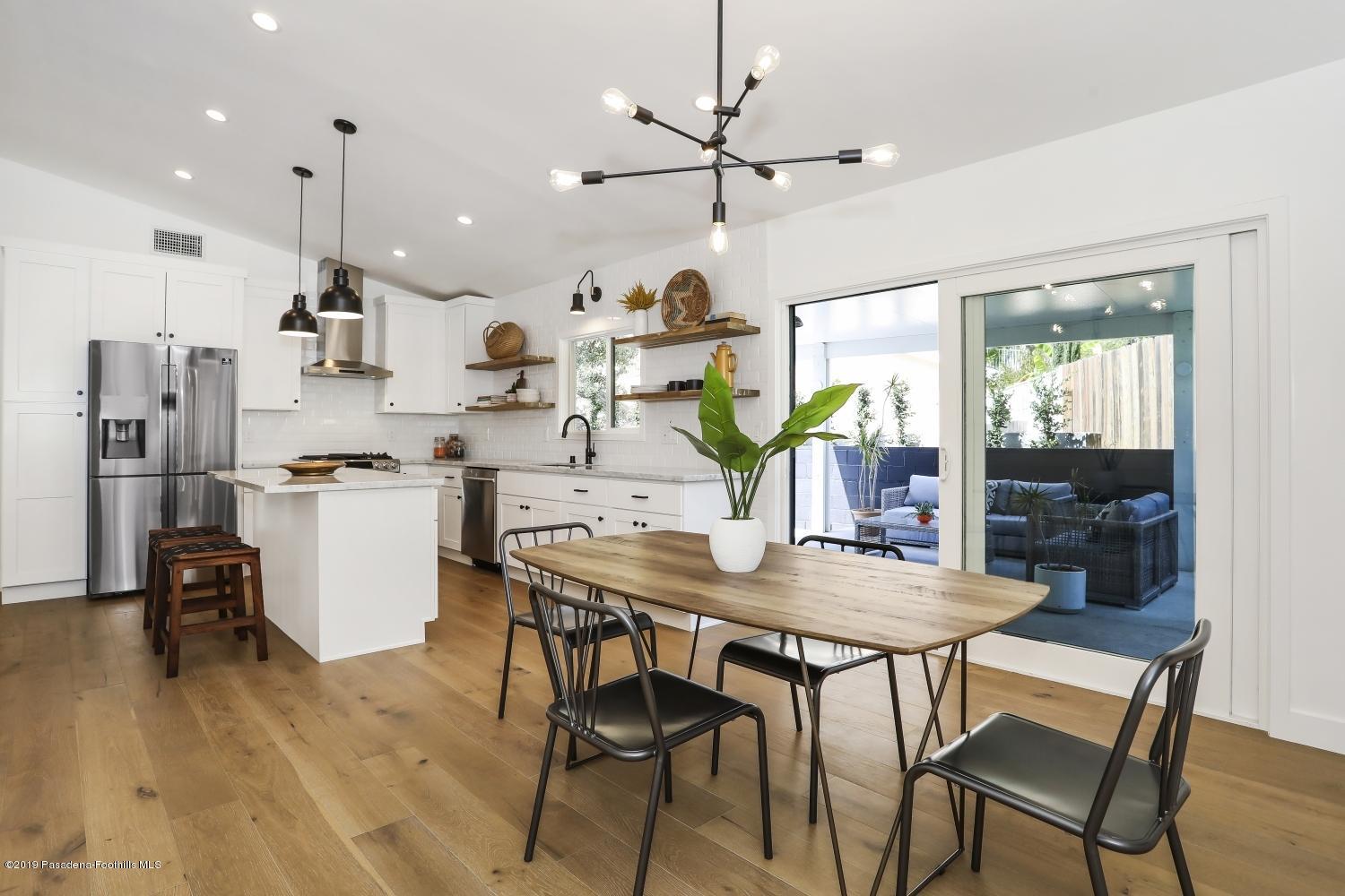 4817 Lockhaven Avenue Los Angeles, CA 90041 - Photo 13 of 34 a view of a dining room and livingroom with furniture wooden floor a chandelier