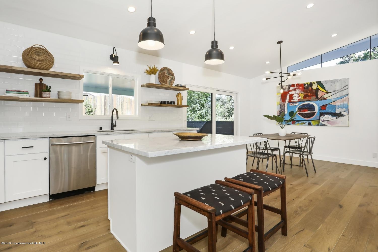 4817 Lockhaven Avenue Los Angeles, CA 90041 - Photo 16 of 34 a kitchen with stainless steel appliances granite countertop a stove a sink a dining table and chairs with wooden floor