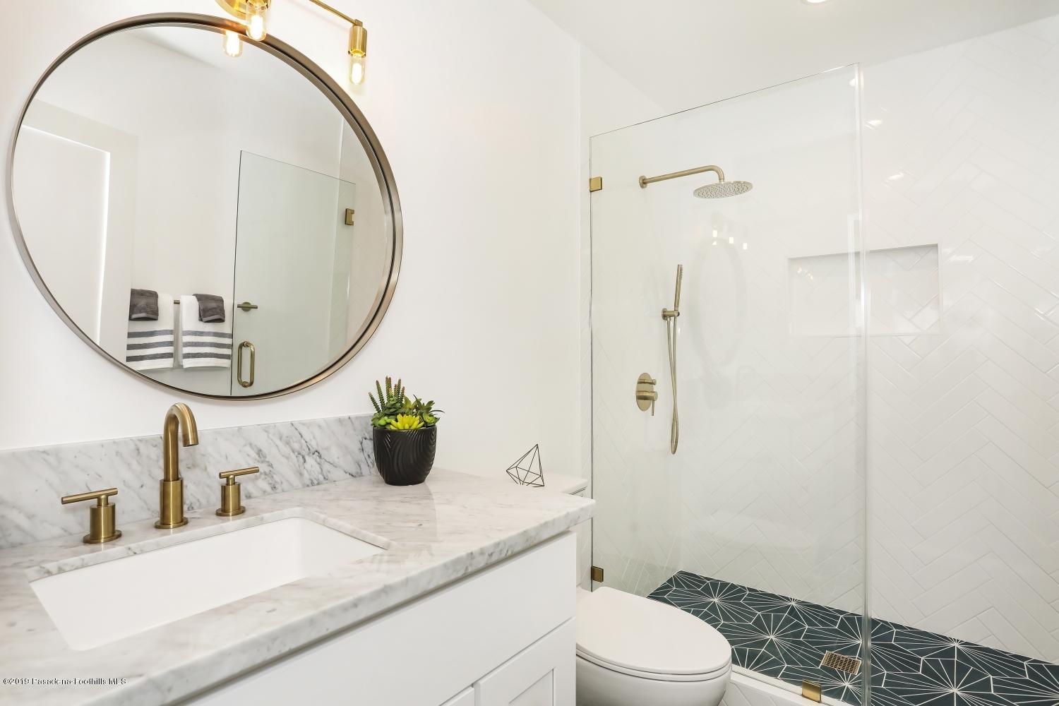4817 Lockhaven Avenue Los Angeles, CA 90041 - Photo 18 of 34 a bathroom with a sink a toilet and a mirror