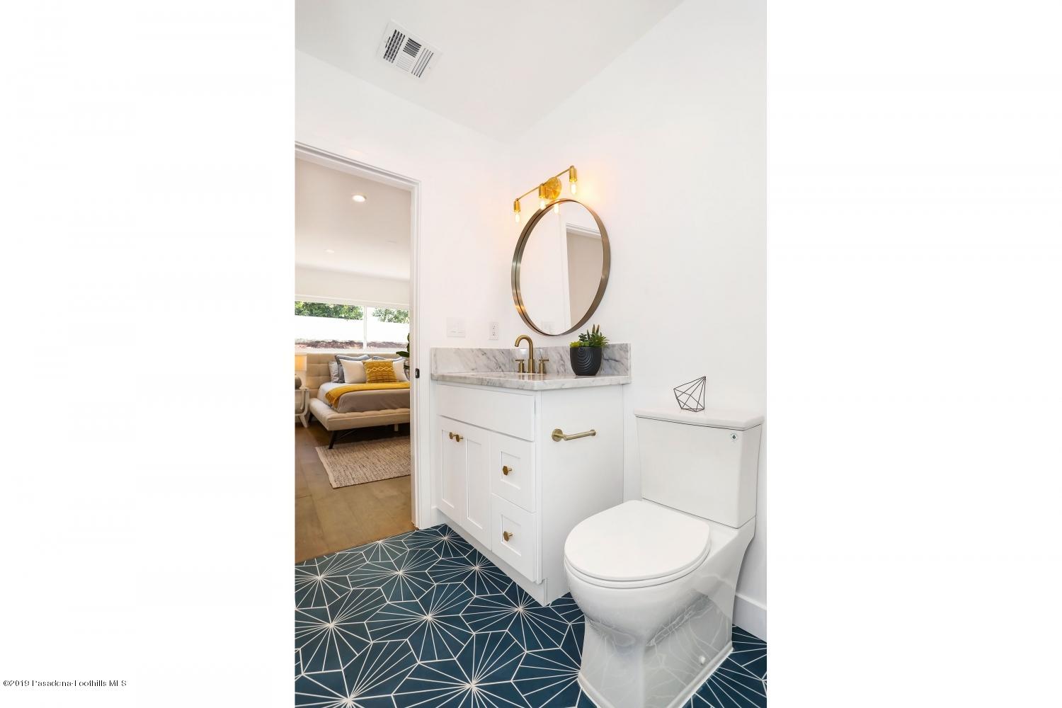 4817 Lockhaven Avenue Los Angeles, CA 90041 - Photo 19 of 34 a bathroom with a toilet sink vanity and mirror