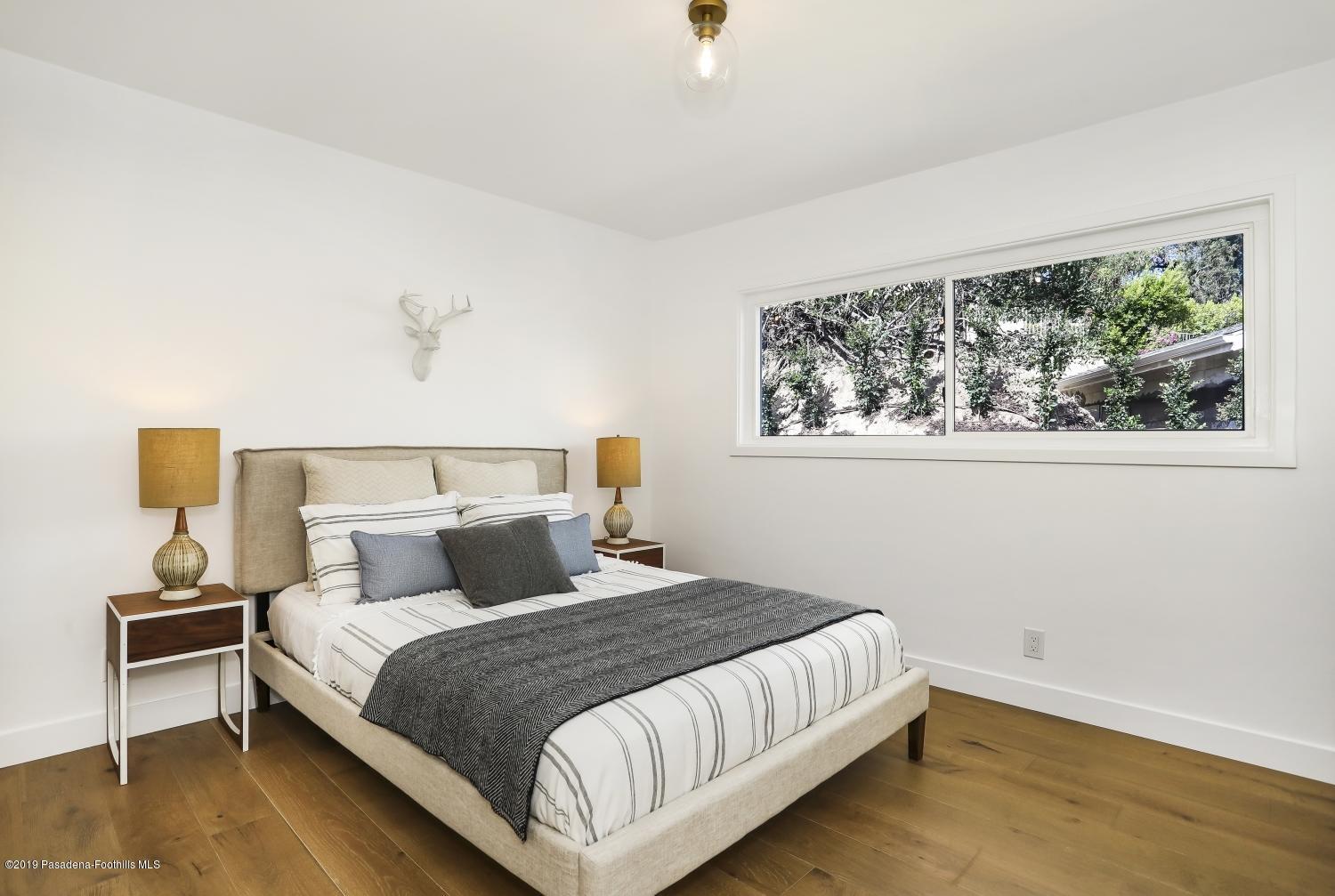 4817 Lockhaven Avenue Los Angeles, CA 90041 - Photo 22 of 34 a bedroom with a bed and wooden floor