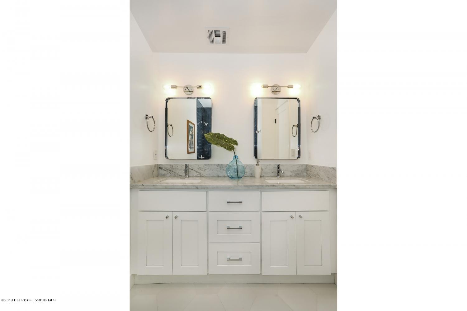 4817 Lockhaven Avenue Los Angeles, CA 90041 - Photo 23 of 34 a bathroom with a granite countertop sink and a mirror