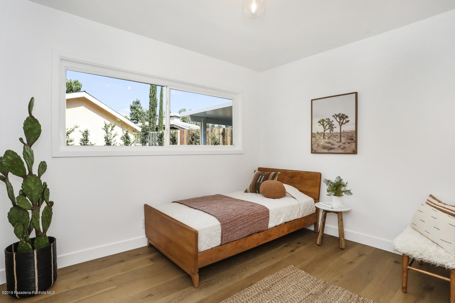 4817 Lockhaven Avenue Los Angeles, CA 90041 - Photo 26 of 34 a bedroom with a bed wall painting and wooden floor