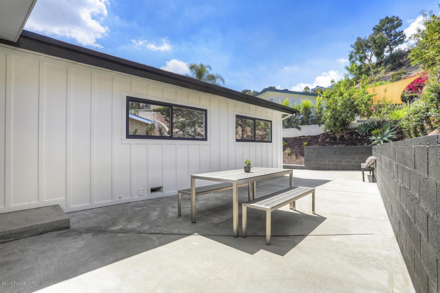 4817 Lockhaven Avenue Los Angeles, CA 90041 - Photo 31 of 34 a view of a patio with a dining table and chairs with wooden fence