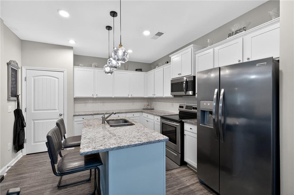 353 Daffodil Drive Temple, GA 30179 - Photo 12 of 30 a kitchen with kitchen island a counter space a sink appliances and cabinets