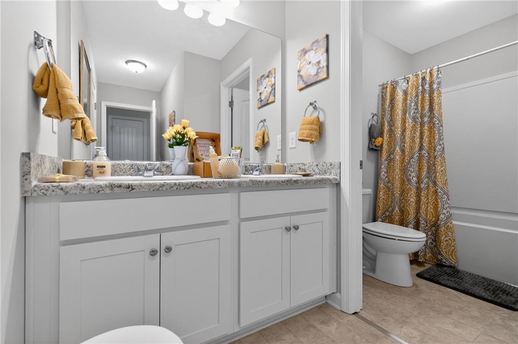 353 Daffodil Drive Temple, GA 30179 - Photo 22 of 30 a bathroom with a granite countertop sink toilet and a mirror