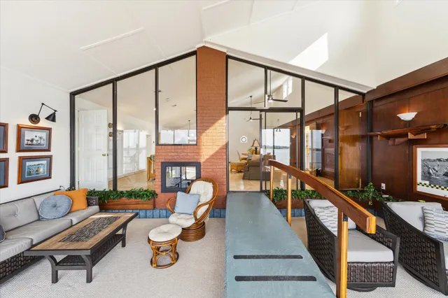 a view of a living room with furniture and floor to ceiling windows