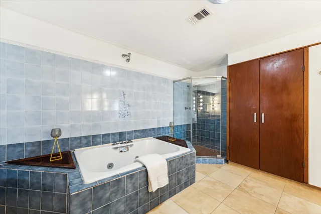 an empty room with chandelier fan and windows