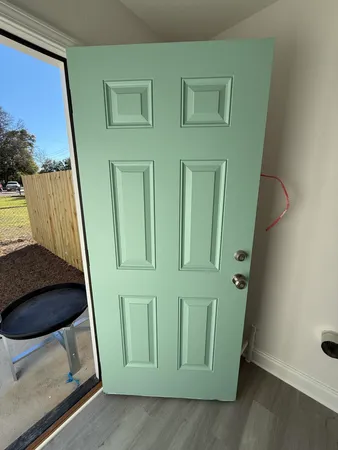 a view of a house with a yard and large tree