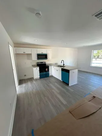 a kitchen with granite countertop a stove top oven and sink