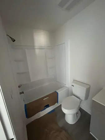 a bathroom with a toilet and a shower