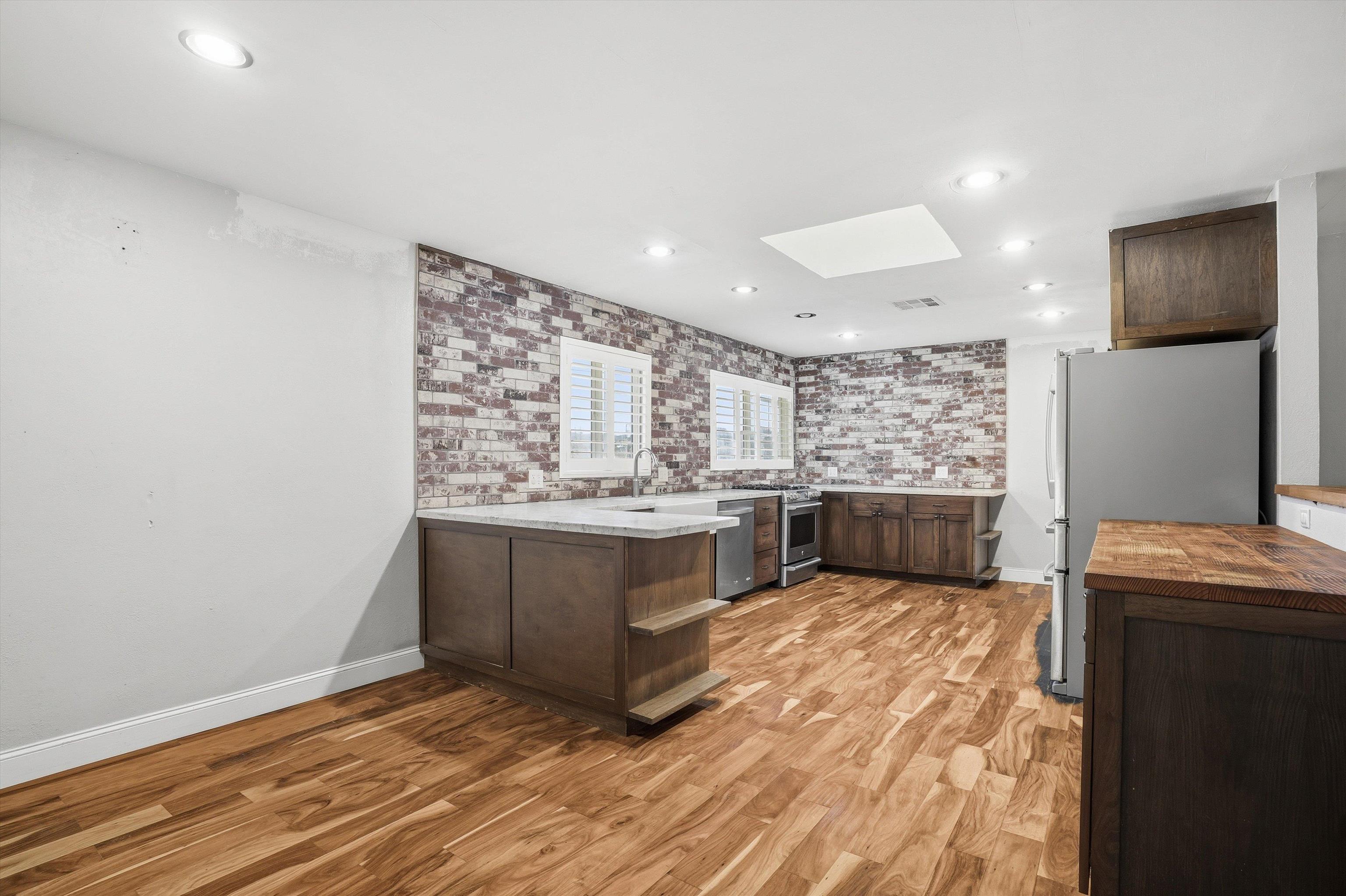 4054 Kimberly Place Concord, CA 94521 - Photo 4 of 16 Kitchen with dark wood finish cabinets, stainless steel appliances, light wood-type flooring, a peninsula, and recessed lighting