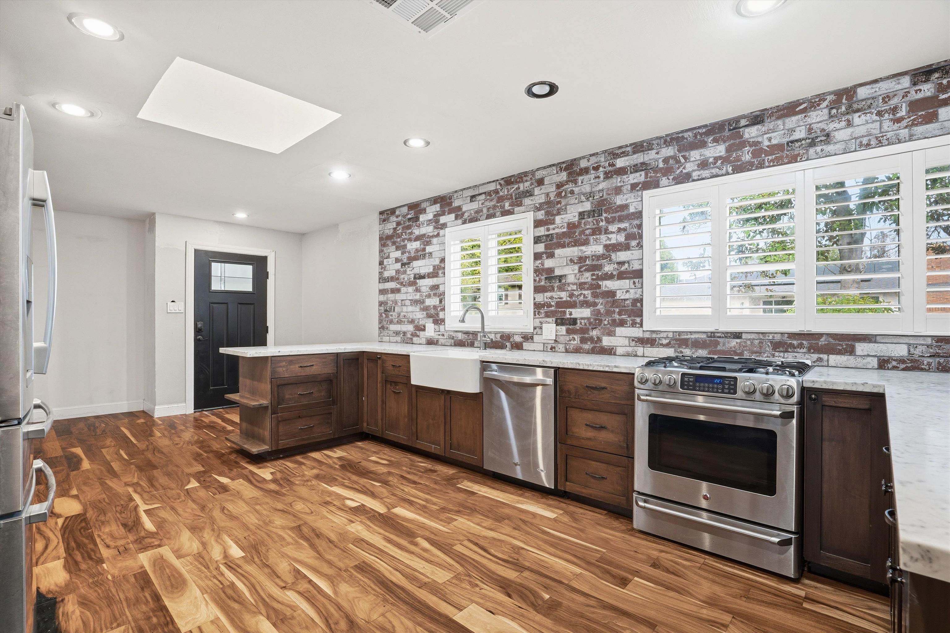 4054 Kimberly Place Concord, CA 94521 - Photo 5 of 16 Kitchen with a peninsula, stainless steel appliances, a skylight, dark wood-type flooring, and dark wood finish cabinets