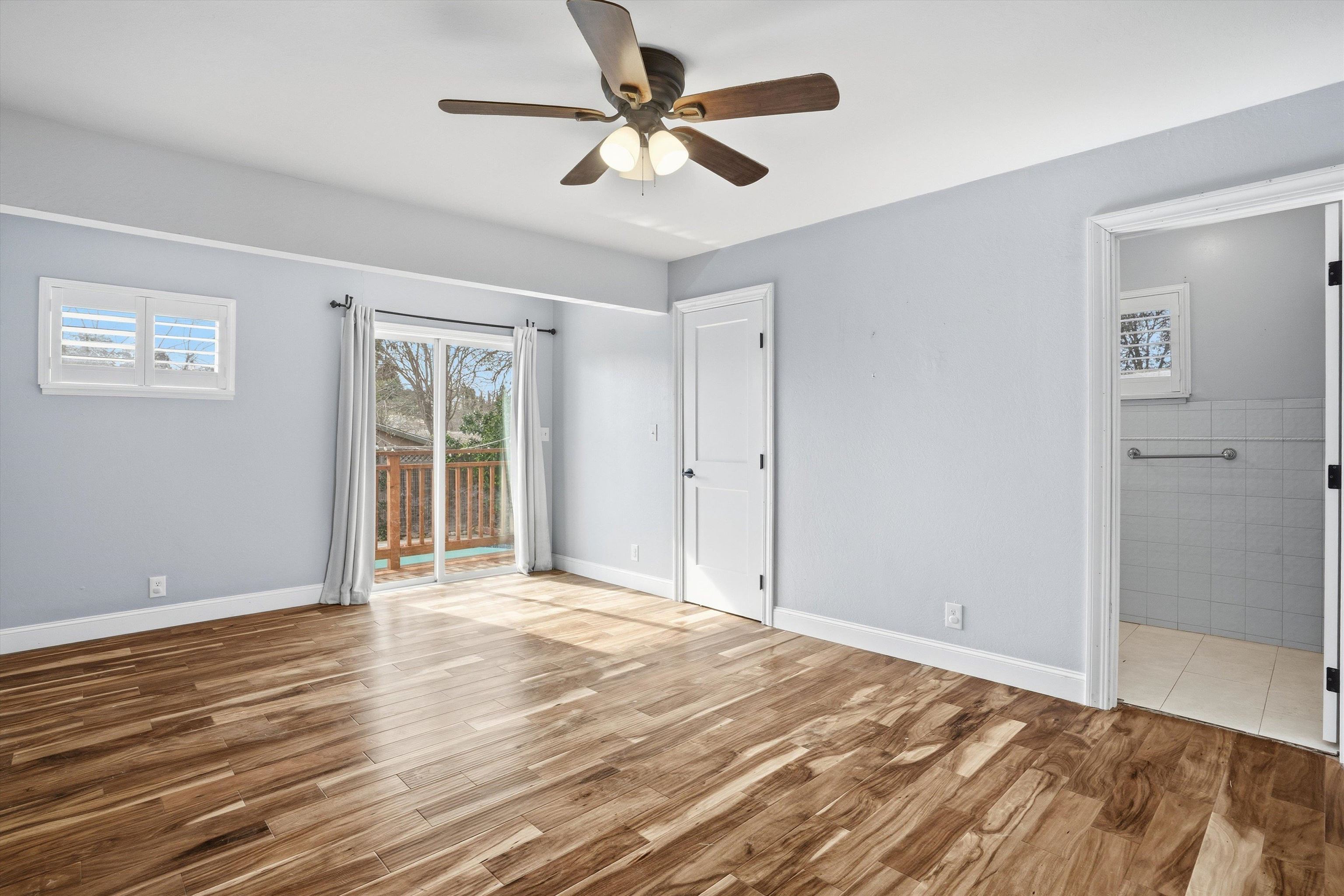 4054 Kimberly Place Concord, CA 94521 - Photo 10 of 16 Master bedroom with ensuite bath, access to exterior, light wood-style floors, & a ceiling fan.
